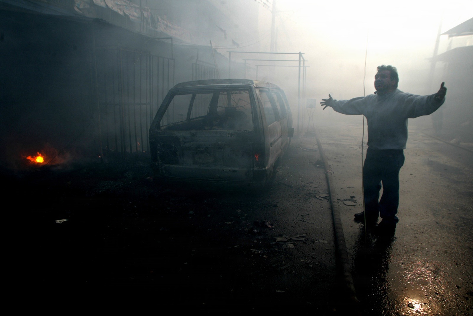A shop owner reacts as a fire rips through a local market November 20, 2006 in Guatemala City. Fifteen people died after one of Guatemala City's largest central market's caught fire Monday, suffocating people trapped inside the labyrinthine building of basic grain and vegetable stalls. REUTERS/Daniel LeClair   (GUATEMALA)
