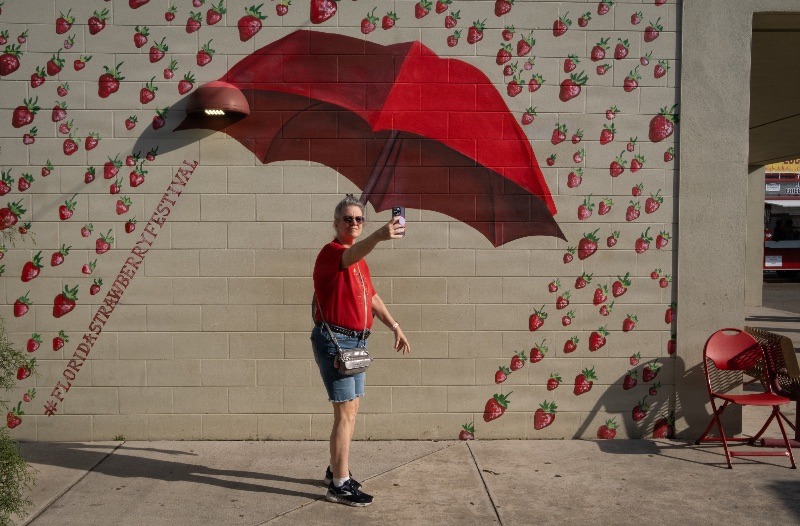 An attendee takes a selfie at the Florida Strawberry Festival in Plant City, Florida March 9, 2025. Photo by Daniel LeClair