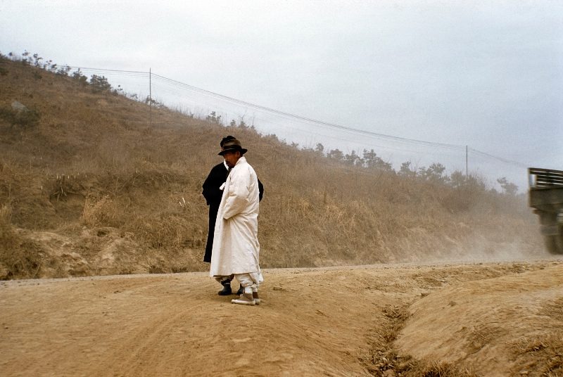 Men standing in road South Korea                               