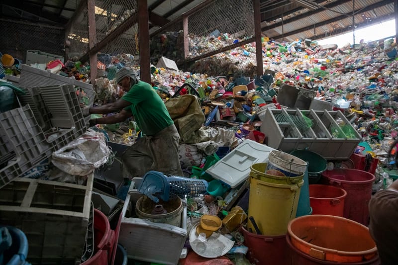 Amidst Mountains of Discarded Plastic, a Worker Sorts for Reuse